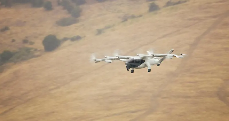 White Archer Midnight eVTOL with tilted front propellers in flight over dry golden hills